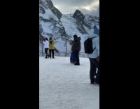 Woman sari dress poses on snowy mountain