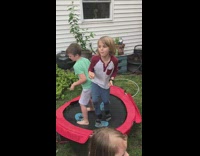 Slow motion of kids jumping on trampoline and one kid knocks the other