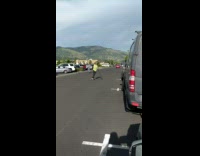 Guy green shirt rowing down street on longboard skateboard