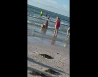 Woman printed dress bend over pose beach