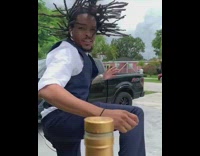 Guy in formal clothing does the bottle cap challenge, misses then chugs Hennessey bottle