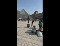Woman stands on a block with the pyramid behind her