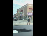 Black skirt girl dances sidewalk road divider 