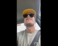 Hat flies away while guy drives car 