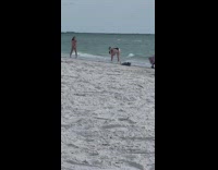 Woman in bikini poses at the beach shore