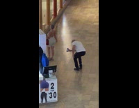 Woman in white dress walks and enters Urban Outfitters Store
