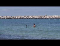 Guy in blue water with two cameras 