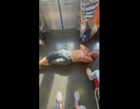 Shirtless man inside train lay on floor