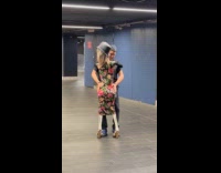 Man dancing with skeleton puppet wearing dress on subway