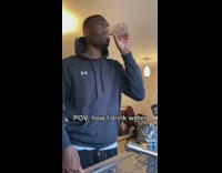 Guy in hoodie drinks cup of water and then dumps it out