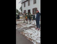 Man with can poses beside historical reenactors