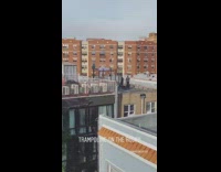 Blue pants girl jumps outdoor trampoline rooftop 