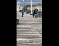 Man uses wheelchair film woman at docks
