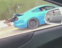 Guy leans out from blue car trunk
