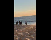 Guy checkered shirt sunglasses tripod beach sunset 