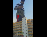 Guy jumps over white and yellow building 