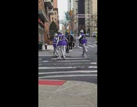 Guys in purple and silver cross street 