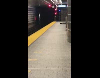 Shirtless guy lays on back subway platform 