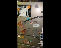 Woman shows nat geo magnetic marble run on fridge