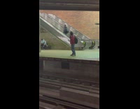 Guy walking up escalator in wrong direction at subway