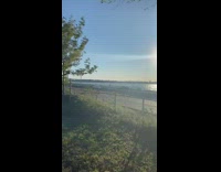 Person kitesurfs kiteboards river water red parachute  