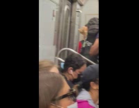 Person on subway with toy doll on backpack