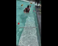 Golden retriever holds onto swim instructor 