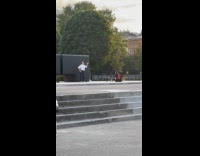 Woman dances front of black stone statue