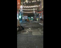 Guy karate chop pose street string lights