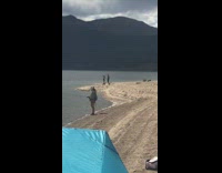 Guy girl exercise arms lake mountain dog 