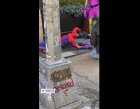Spiderman and green goblin stand in sidewalk 
