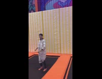 Guy jumps onto velcro wall on trampoline, hits his face on wall and falls down