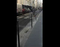 Collab IITW - Woman in black dress and checkered coat walks on the street