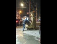 Two people transport large gold buddha statue 