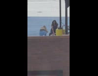 Girl glasses black dress kneel smile rooftop