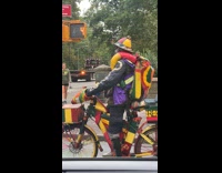 Collab WINY - Man rides bicycle covered in Jamaican colors