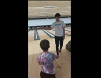 Guy bowling handshake picks up kid 