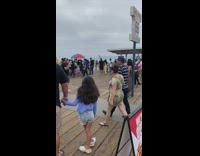 Woman leopard print dress stands on Santa Monica signage