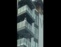 Lady in White Undergarment Leans on Glass Balcony