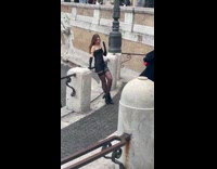 Woman in black outfit poses near the statue