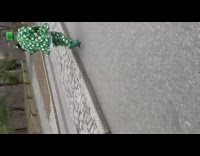 Guy wearing green suit runs kicks ball 