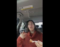 Girl eating with white fork in car red sweater 