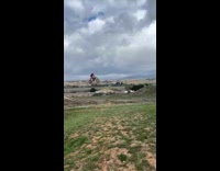 Dirt biker flies over hill 