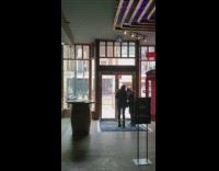 Girls pose with red phone booth restaurant 