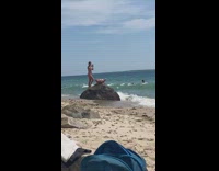 Woman bikini lays on beach rock for photoshoot Part 2