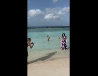 Tourists pose with flamingos in water