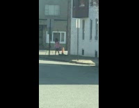 Woman in pink coat poses on the sidewalk