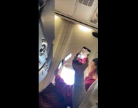 Man films woman with lights inside airplane