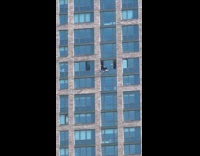 Man washes the window on high floor