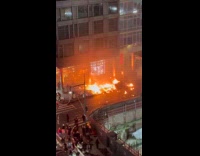 Garbage on fire on side of street